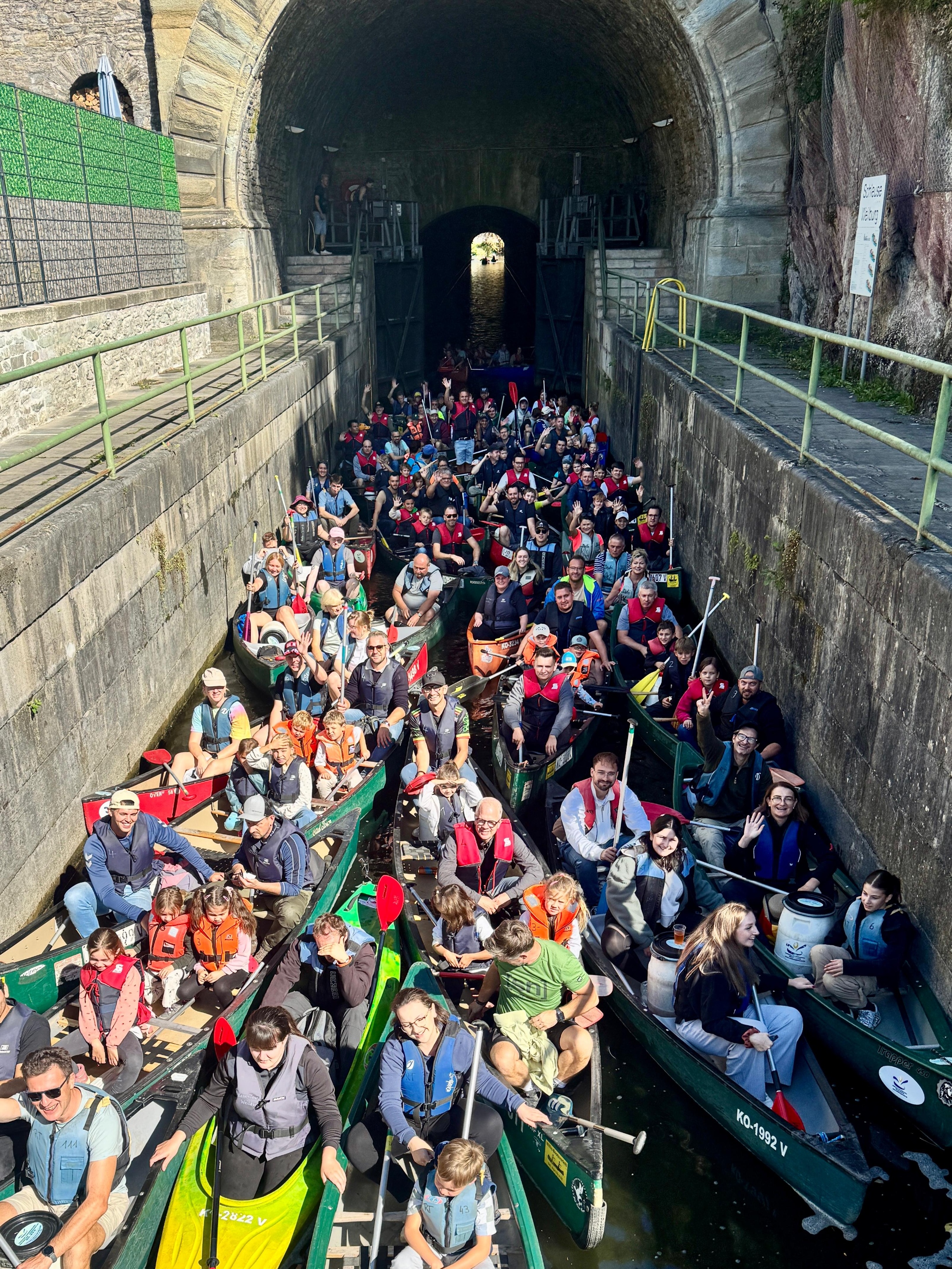 Alle Teilnehmenden sitzen in ihren Booten in der engen Schleusenkammer am Ende des Weilburger Schiffstunnels.