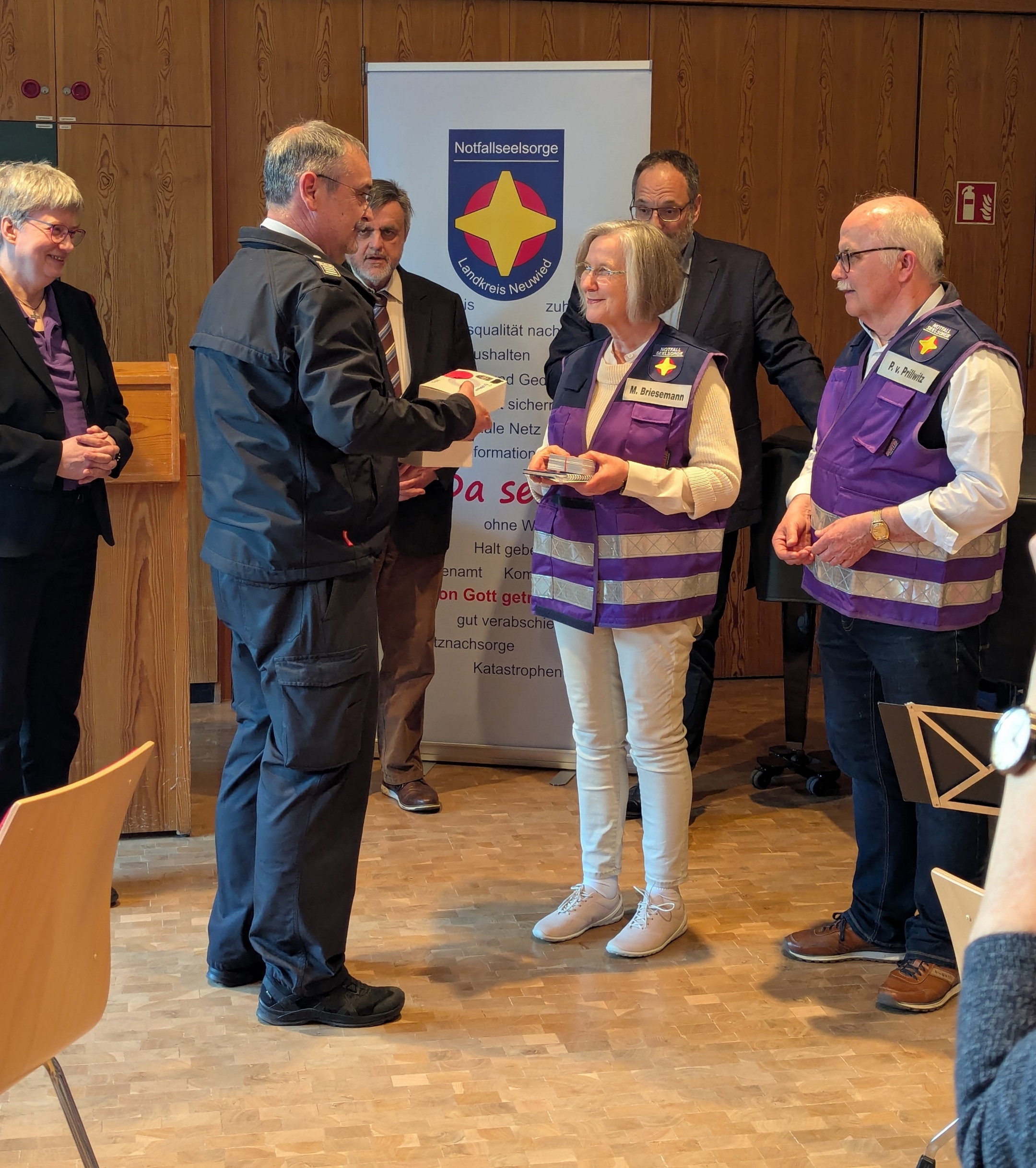 Marianne Briesemann und Peter von Prillwitz erhalten aus den Händen des stellvertretenden BKI Volker Lemgen die digitalen Meldeempfänger.