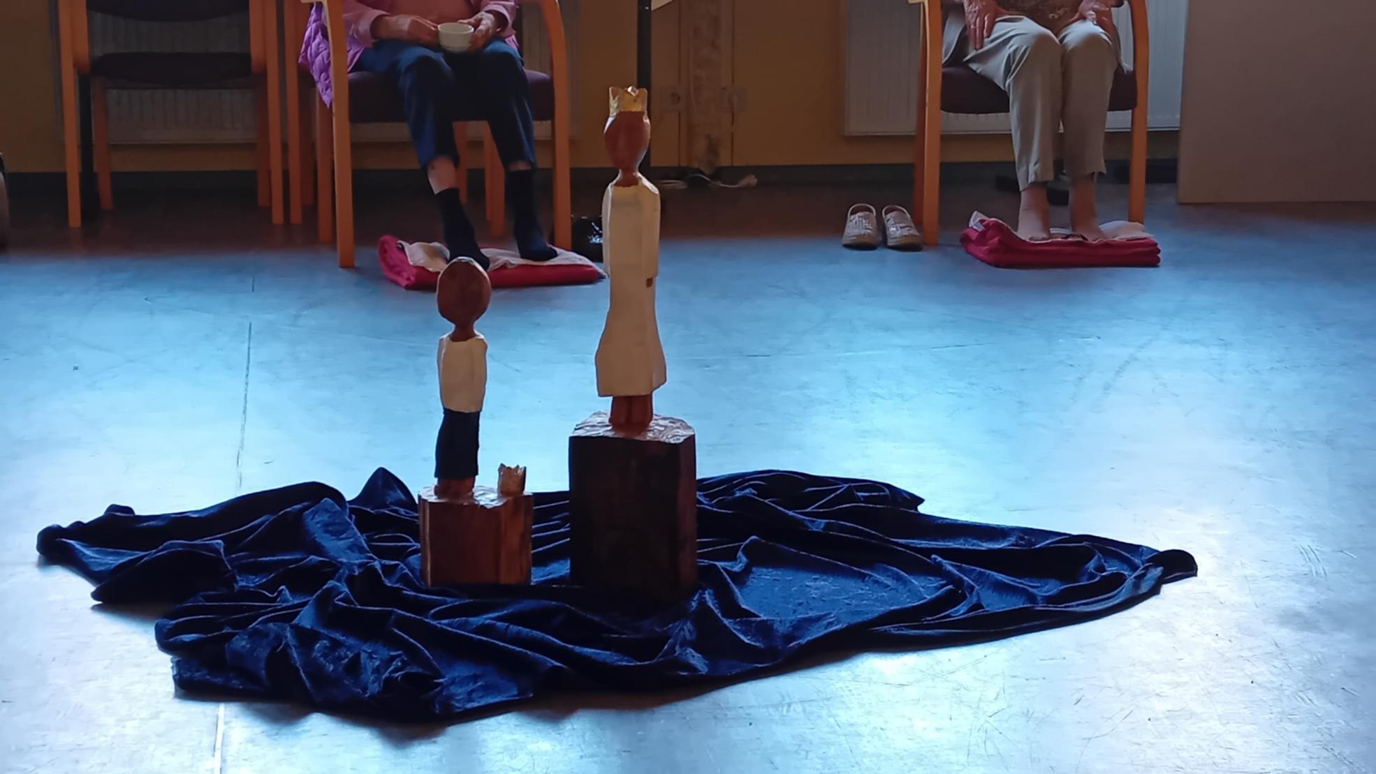 Die beiden Königsfiguren des Pastoralen Raumes Neuwied stehen auf einem blauen Samttuch in der Mitte eines Stuhlkreises.