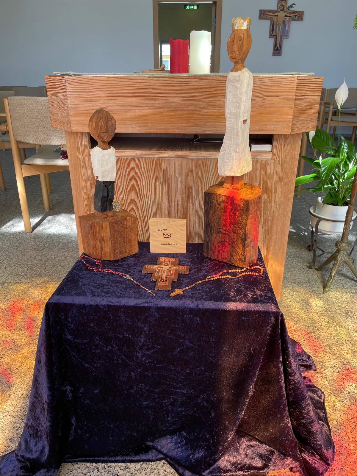 Die beiden Königsfiguren des Pastoralen Raumes Neuwied stehen leicht erhöht auf einem blauen Samttuch vor dem Altar. Auf dem Tuch liegen auch ein Assisikreuz sowie zwei Rosenkränze.