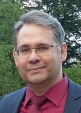 evangelischer Pfarrer Andreas Beck, freundliches Lächeln, graue Haare mit rechtem Seitenscheitel, randlose Brille