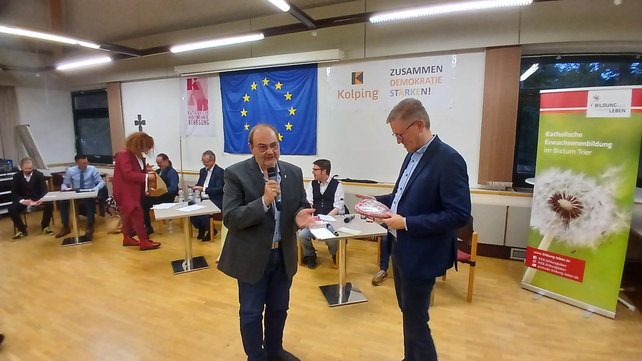 Monika Hommer, KAB-Vorsitzende (3.v.l) und Diakon Michael Hommer (l.) mit Marcelo Peerenboom (r.) stehend bei der Überreichung von kleinen Dankeschönpräsenten