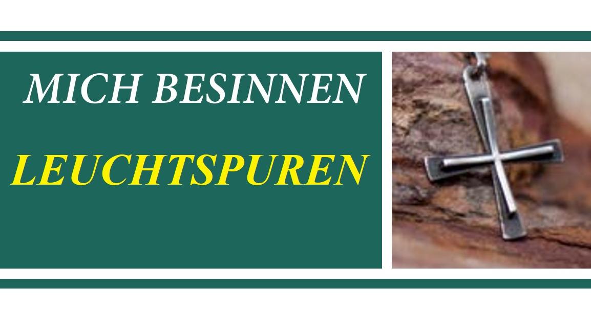 Ein kleines Halskreuz liegt auf einer Baumrinde.