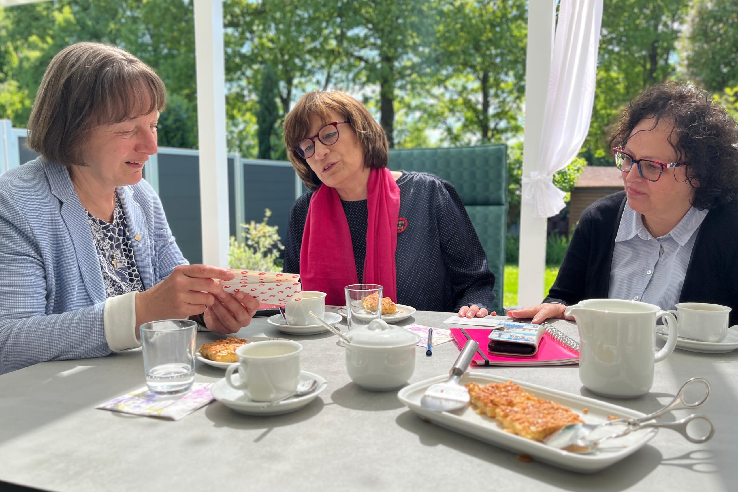 An einer gedeckten Kaffeetafel unterhalten sich die Verantwortlichen.
