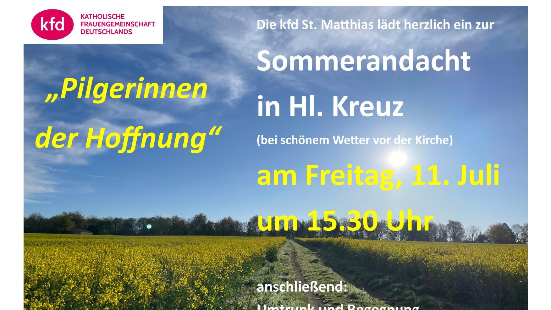 Ein grasbewachsener Feldweg führt durch Rapsfelder auf einen baumbestandenen Horizont zu, unter blauem Himmel mit leichten Schleierwolken.