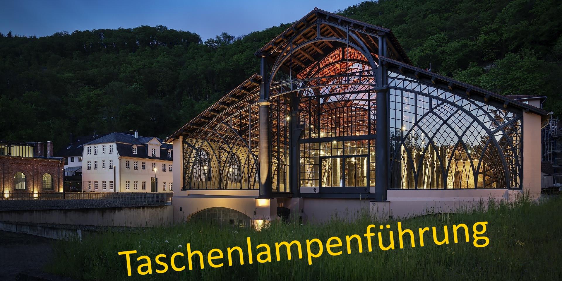 Die Beleuchtung der Sayner Hütte, eine ehemalige Gießhalle hauptsächlich bestehend aus einem Ständerwerk aus Eisen, strahlt in die Dämmerung.