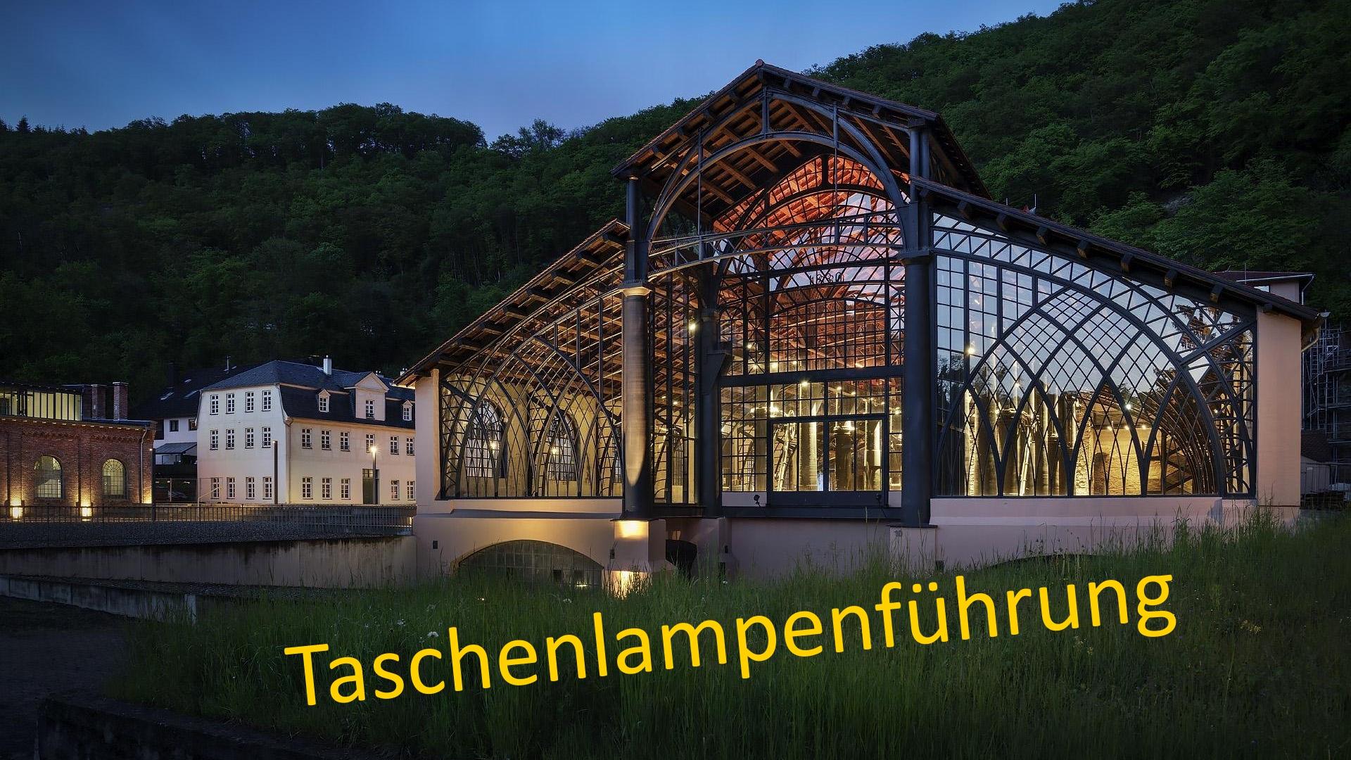 Die Beleuchtung der Sayner Hütte, eine ehemalige Gießhalle hauptsächlich bestehend aus einem Ständerwerk aus Eisen, strahlt in die Dämmerung.