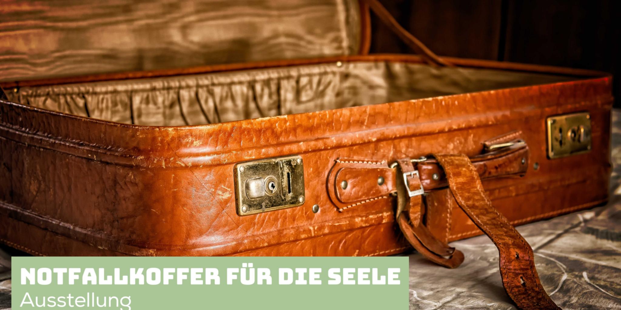 Das Bild zeigt einen aufgeklappten, leeren alten hellbraunen Lederkoffer.