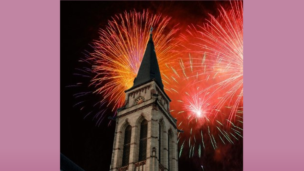 Der Kirchturm von St. Matthias Neuwied erstrahlt im Silvester-Feuerwerk.