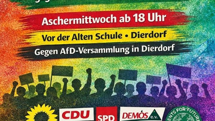 Ein Plakat in Regenbogenfarben, das auch die Schatten einer demonstrierenden Menge zeigt, lädt zur Mahnwache ein.