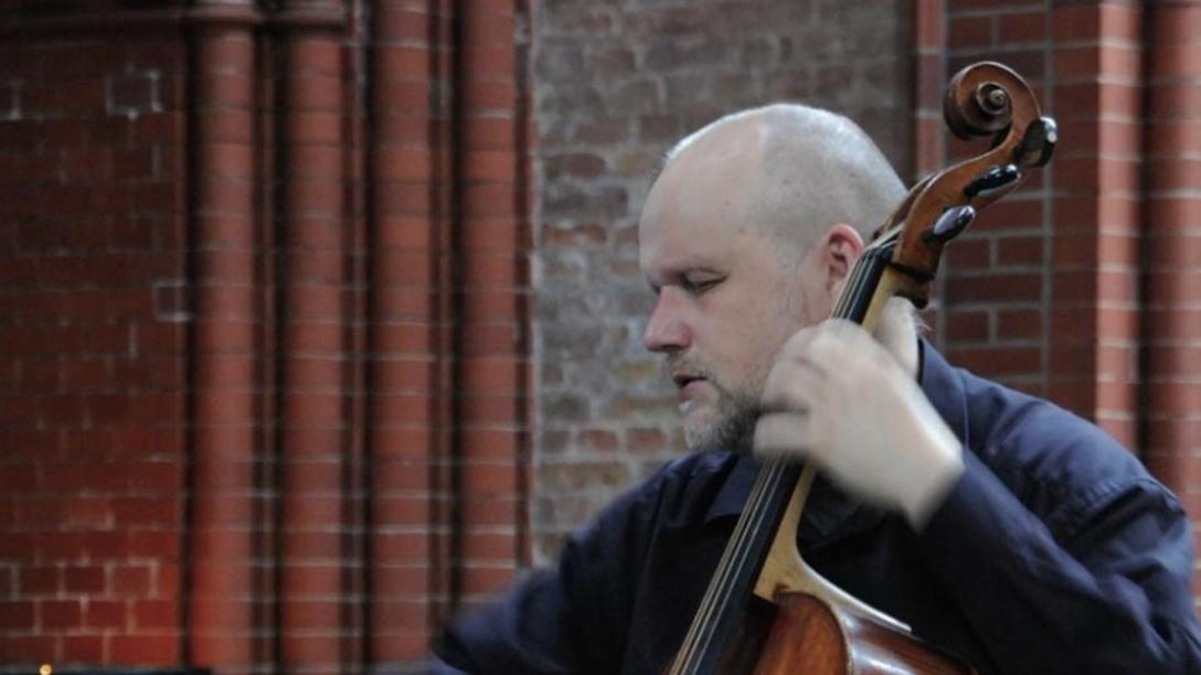 Ludwig Frankmar, ein Mann mittleren Alters mit Vollbart und kurzgeschorenen Haaren, spielt hingebungsvoll - mit geschlossenen Augen - auf seinem Barockcello.