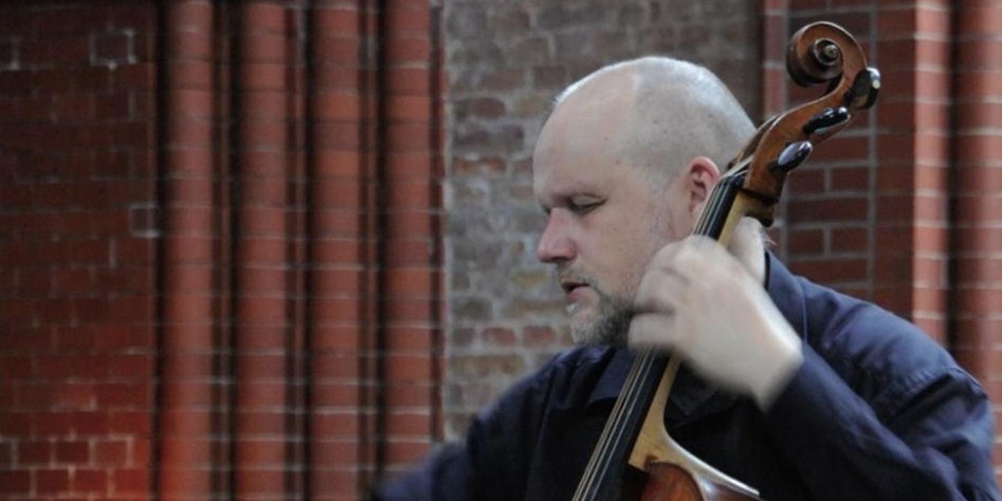 Ludwig Frankmar, ein Mann mittleren Alters mit Vollbart und kurzgeschorenen Haaren, spielt hingebungsvoll - mit geschlossenen Augen - auf seinem Barockcello.