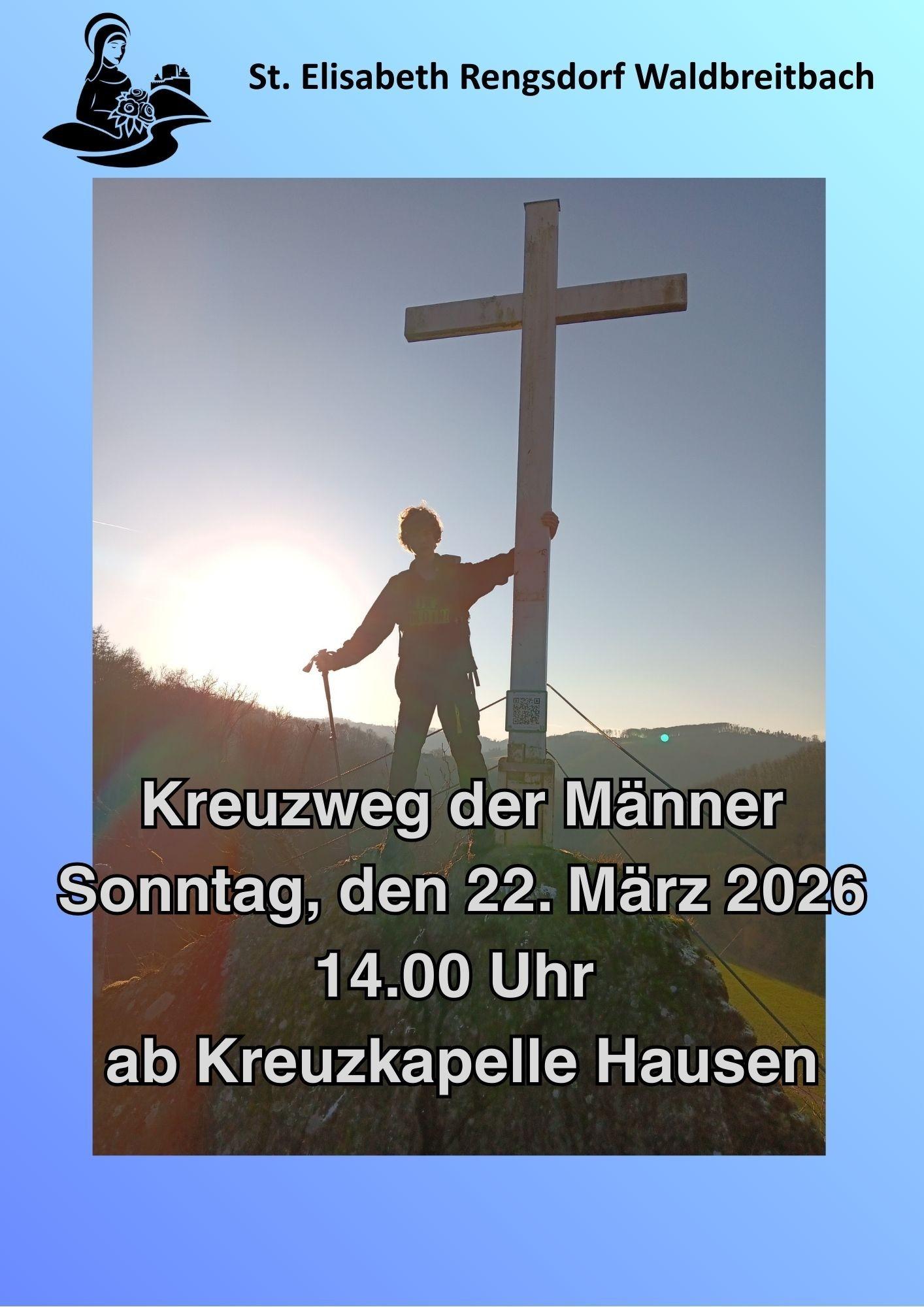 Im Gegenlicht steht ein junger Mann auf einem Berg an einem Gipfelkreuz.