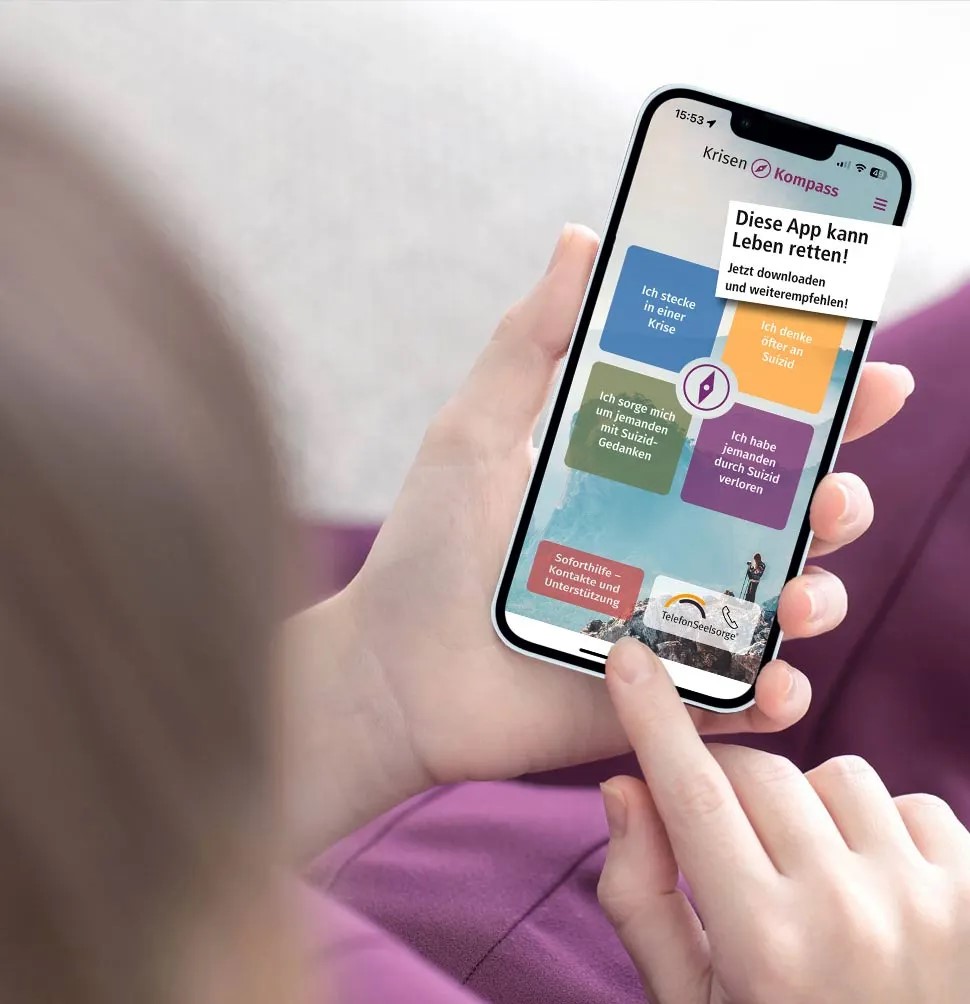 Zwei Hände halten ein Smartphone, auf dem die App 'Krisenkompass' geöffnet ist.